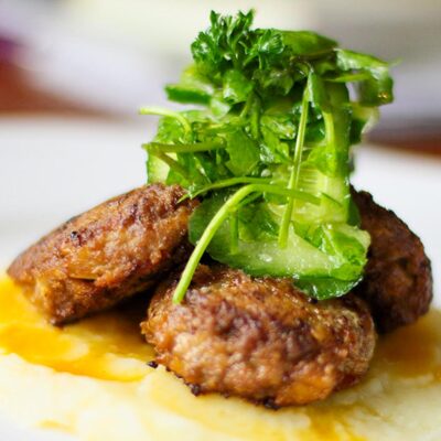 Delicious and exquisite veal patties served on top of mashed potatoes and topped with herbs