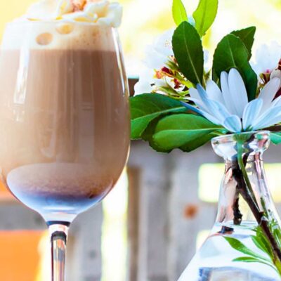Delicious Serving Coffee Whipped Cream near a water vase with flowers