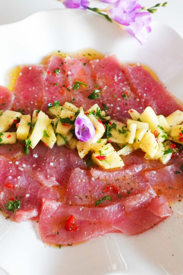 Beautiful tuna carpaccio with pineapple salsa on a big plate