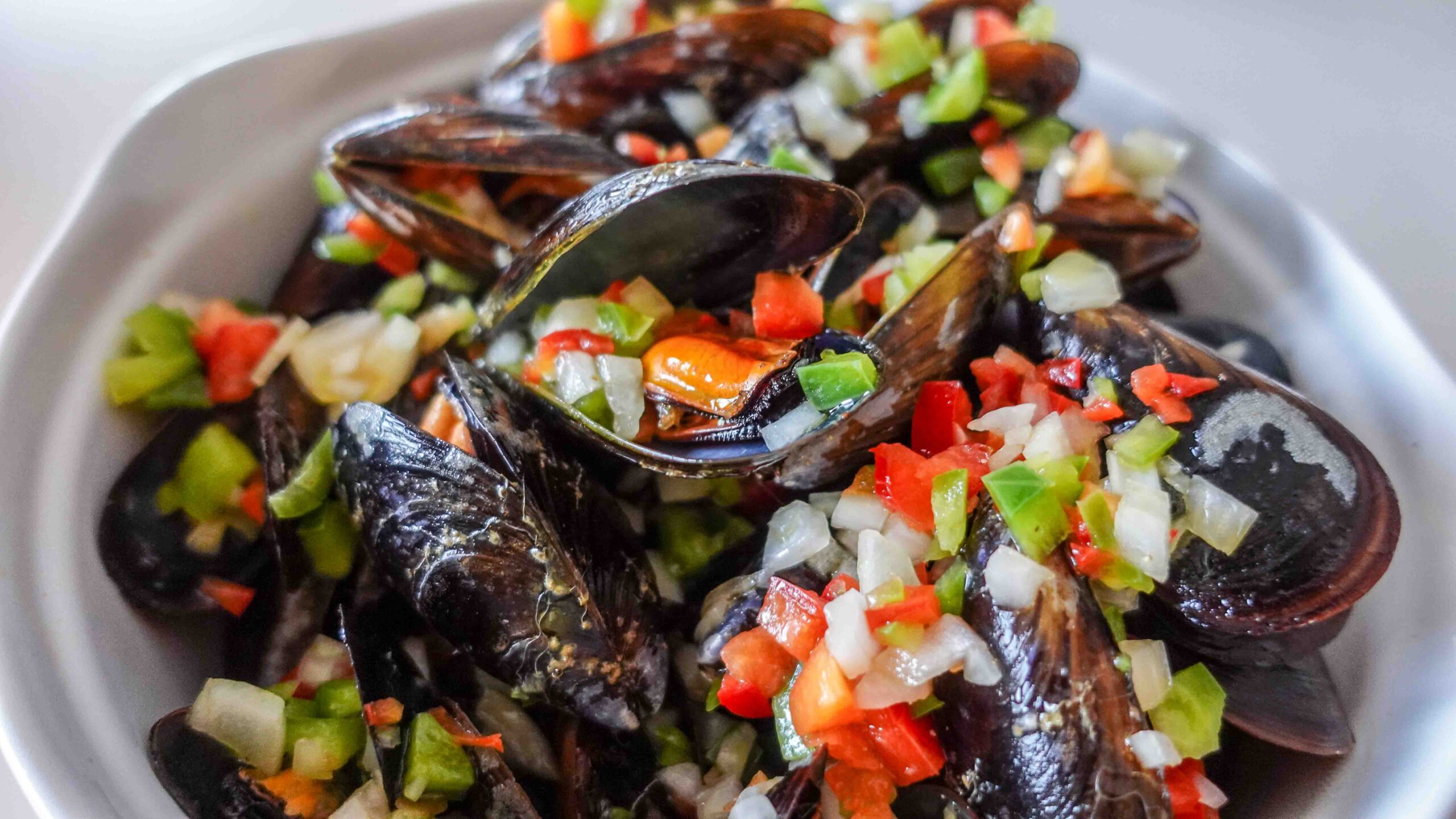 Ready mussels in a big bowl with salsa