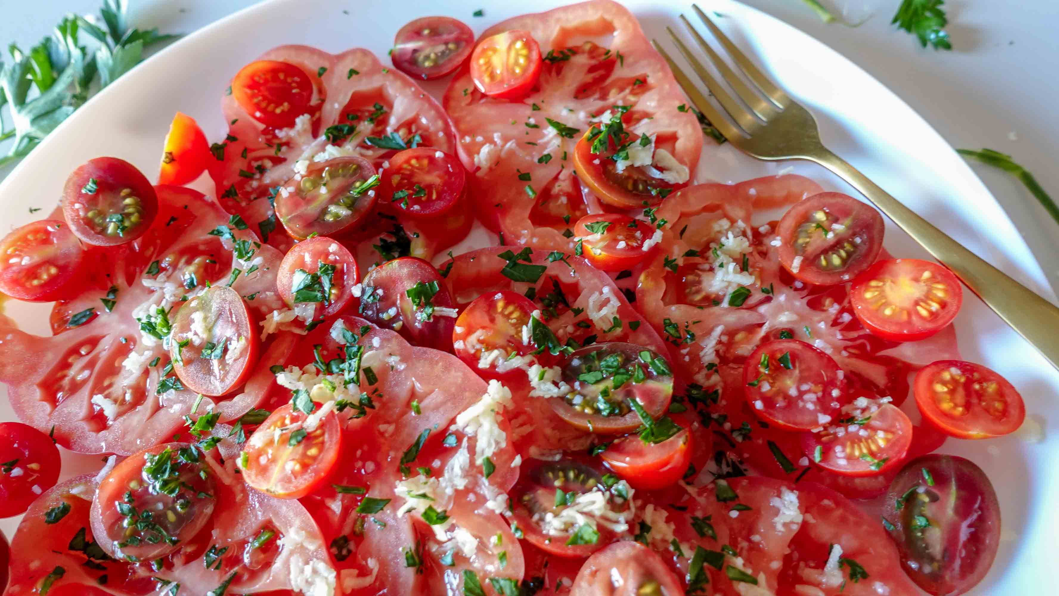 Garlic Tomato Salad on a plate with parsley on a side