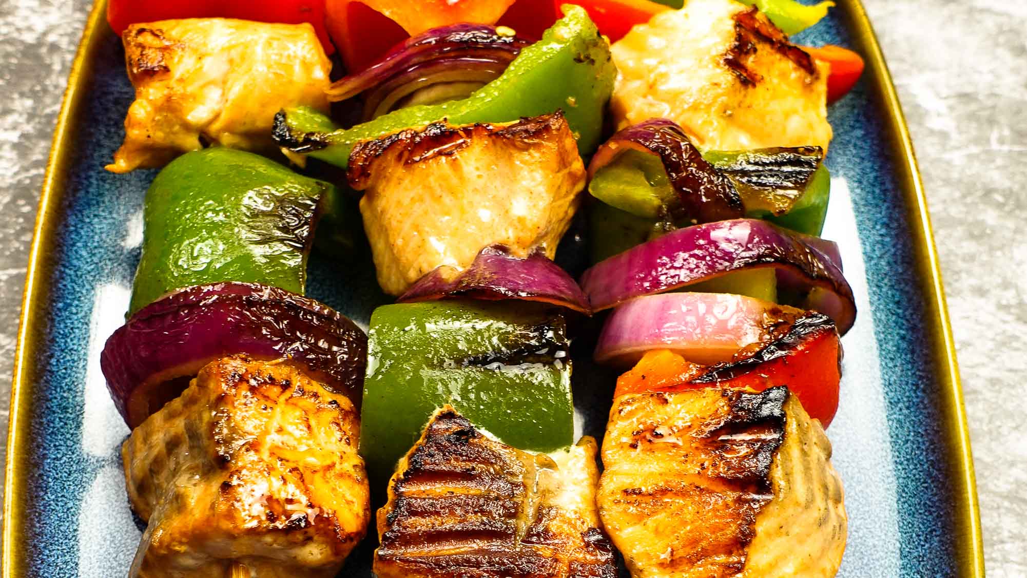 Perfectly cooked Mediterranean Salmon Kabobs on a plate.