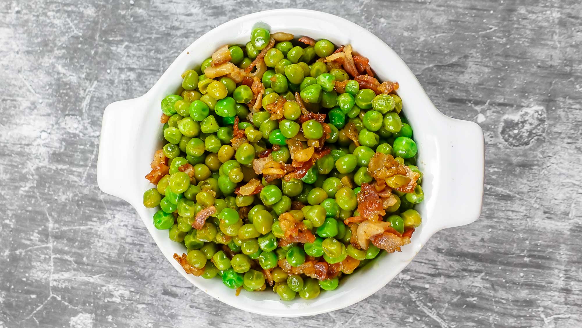 Mediterranean Peas with Bacon in a white bowl.