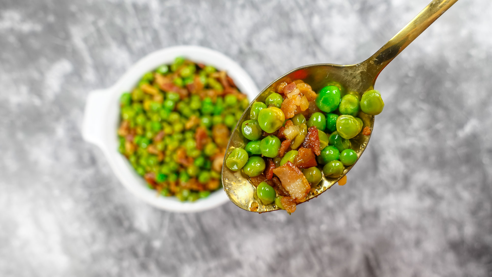 Delicious Mediterranean Peas with Bacon in a white bowl.