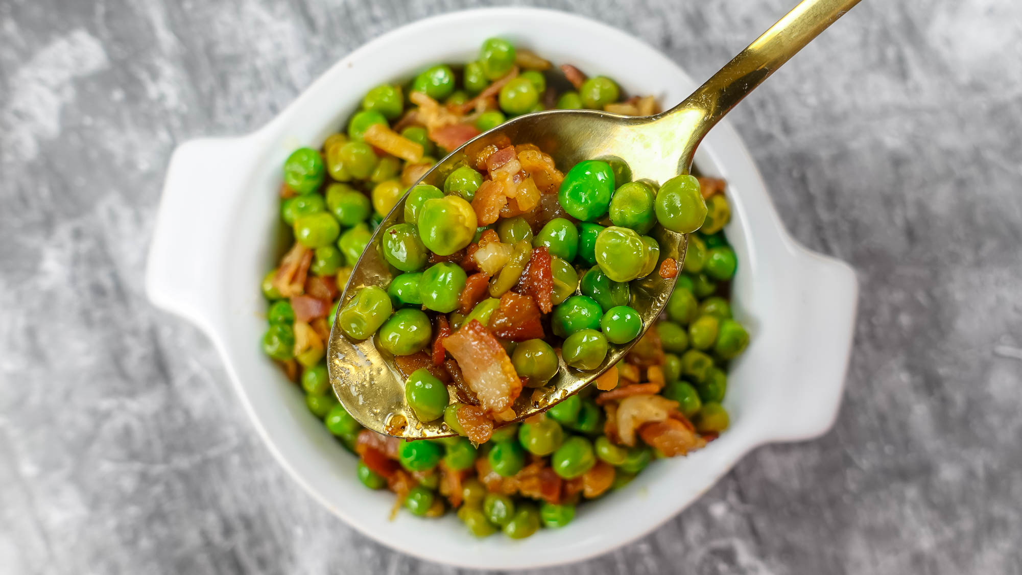 Delicious Mediterranean Peas with Bacon in a white bowl.