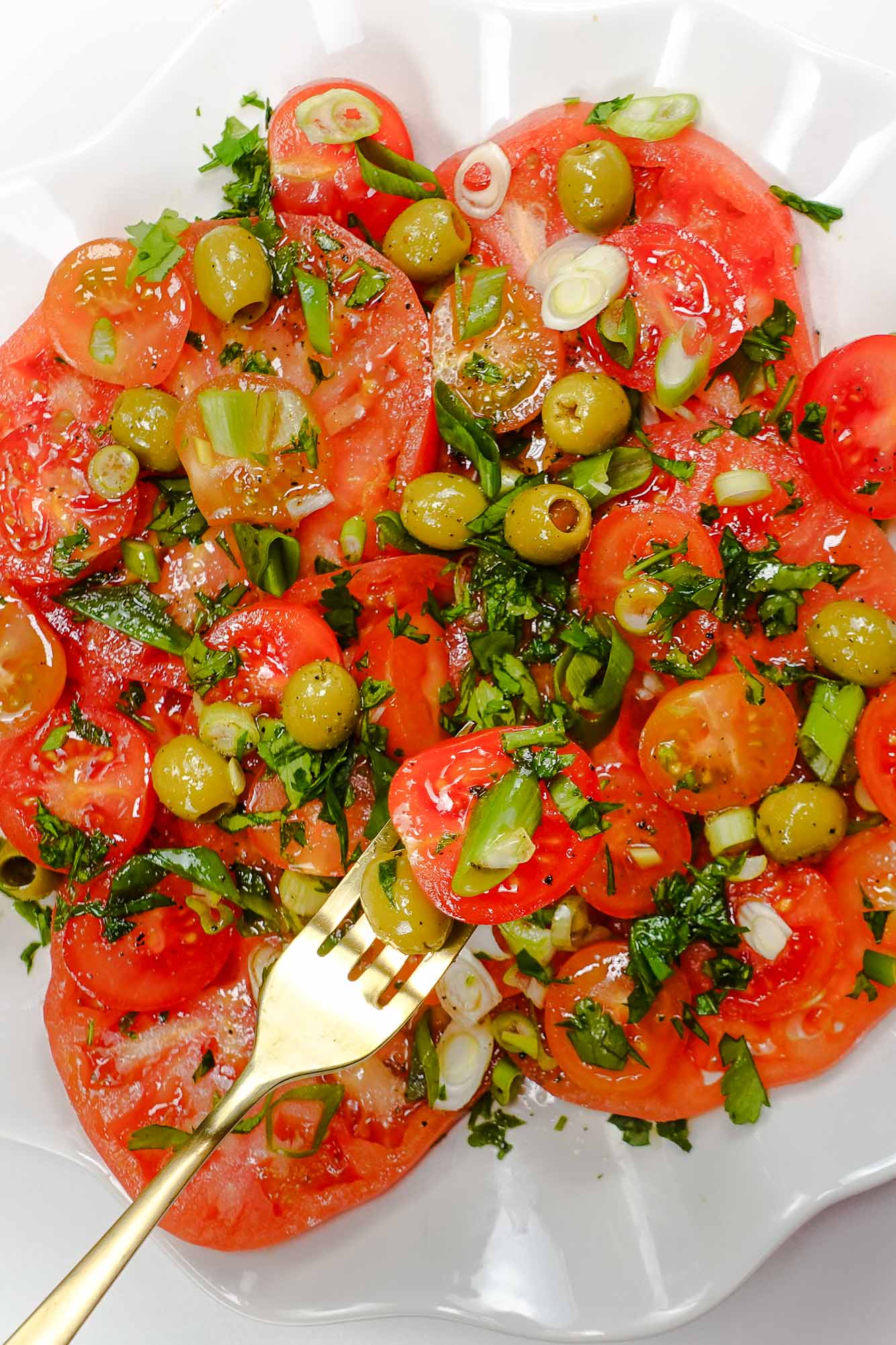 Tomato Salad on a plate and a fork full of salad.