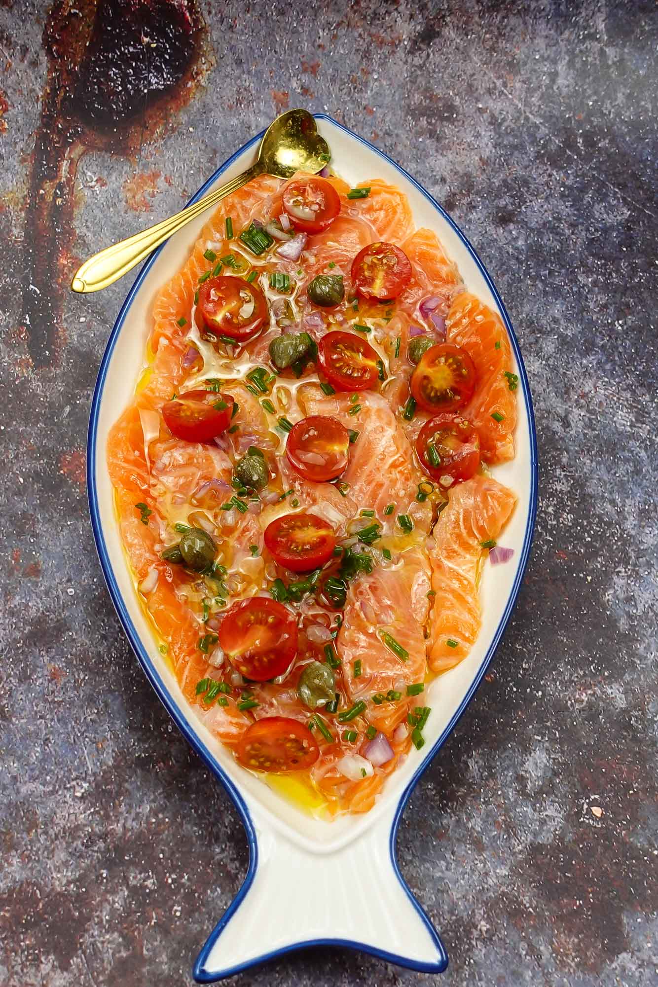 Mouthwatering Salmon Carpaccio on a plate with a spoon.