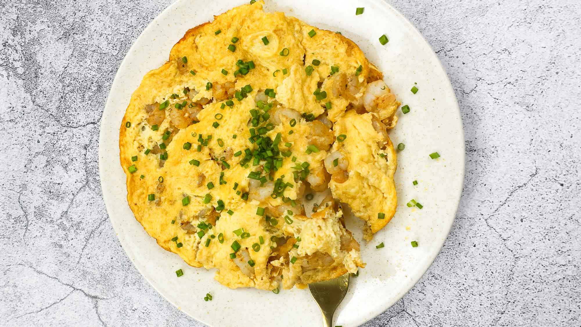 Shrimp Omelette on a plate with green onion.