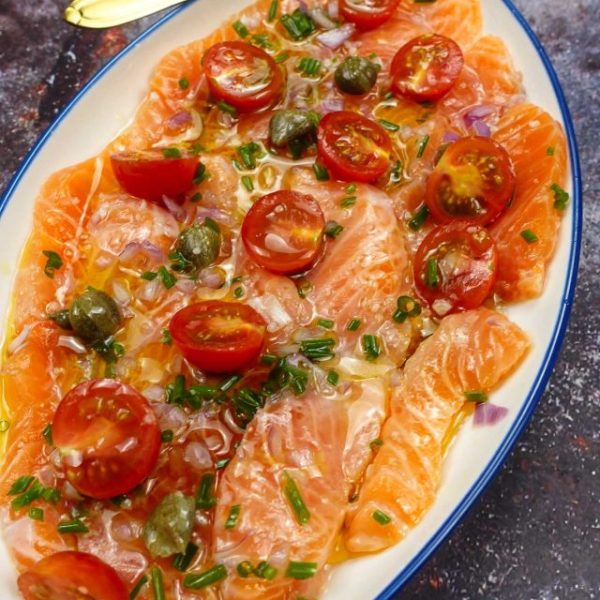 Delicious Salmon Carpaccio on a plate with a small spoon.