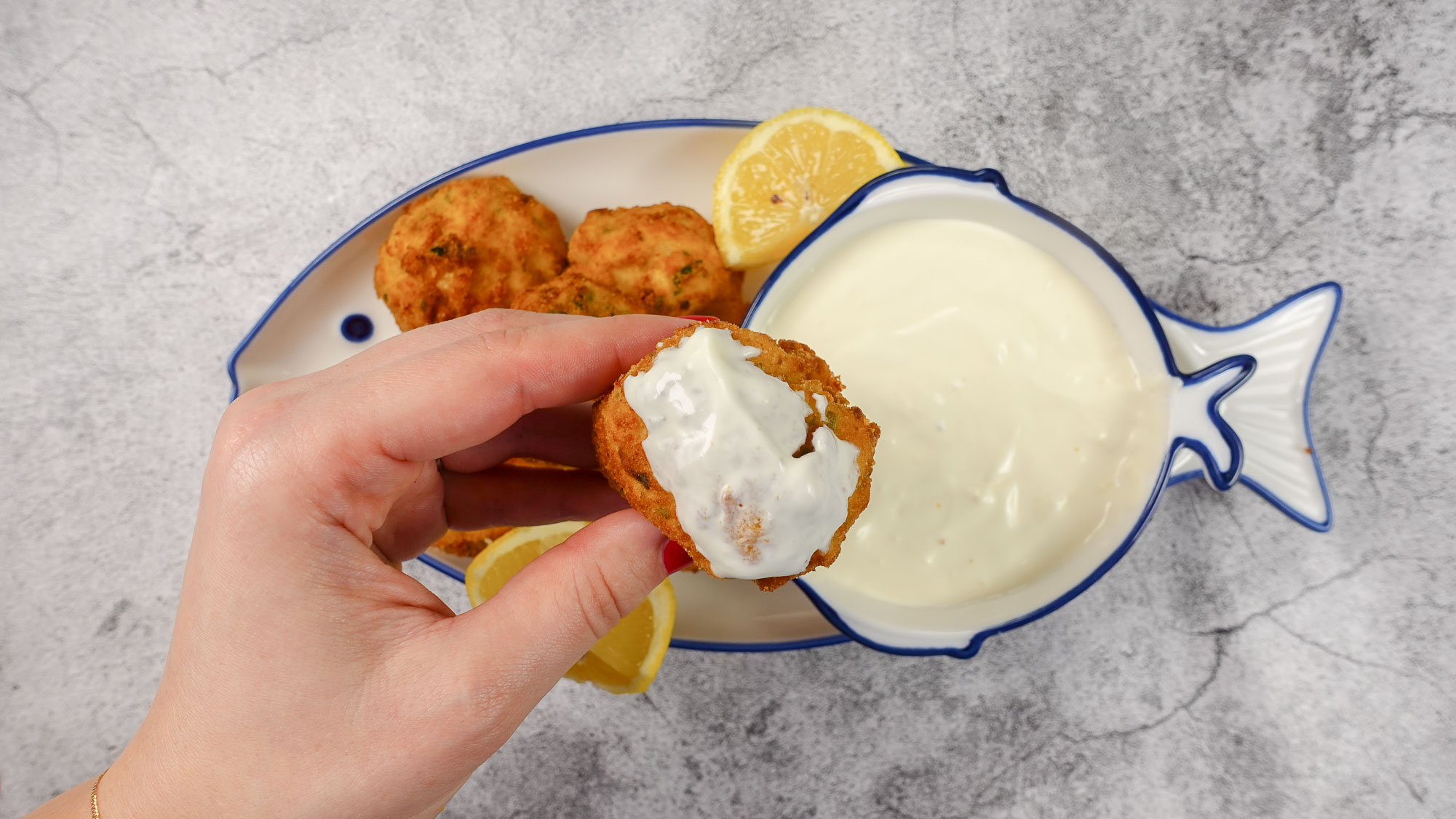 A croquette dipped in a white sause.